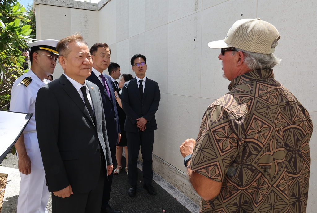 Minister Lee Sang-min listens to an official from the National Memorial Cemetery of the Pacific after laying a wreath at the National Memorial Cemetery of the Pacific in Honolulu, Hawaii, U.S., on the afternoon of the 6th (local time).